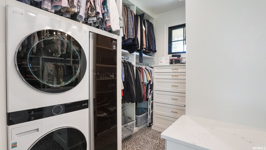 Laundry area featuring carpet flooring and stacked washer and dryer