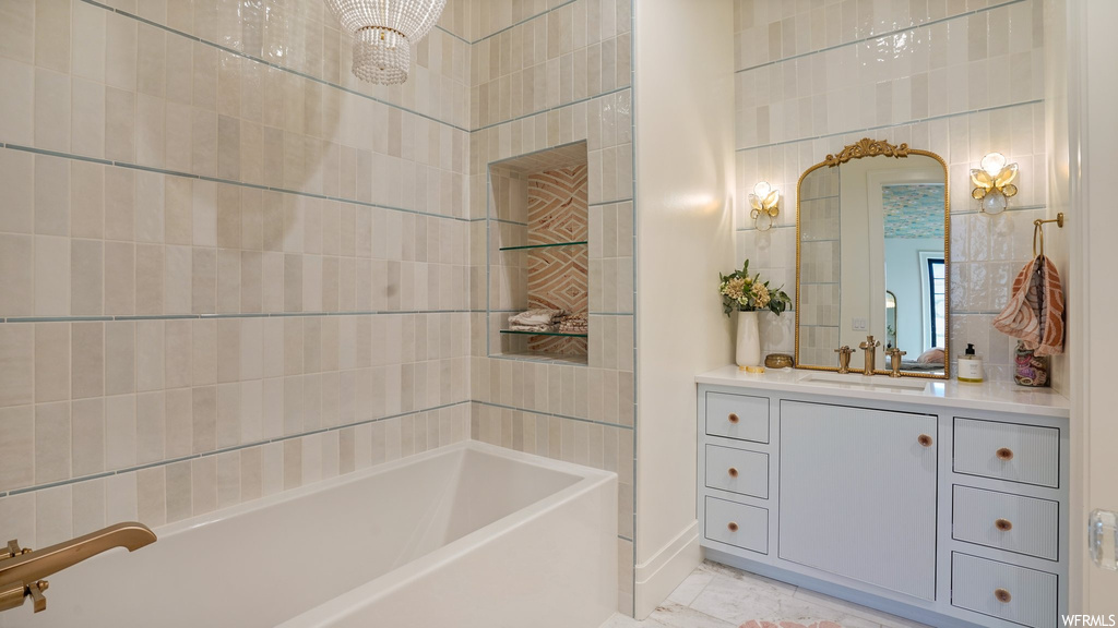 Bathroom featuring tile floors, tub / shower combination, vanity, and tile walls