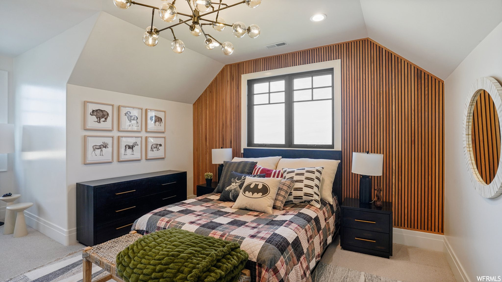 Carpeted bedroom with a chandelier, lofted ceiling, and wood walls