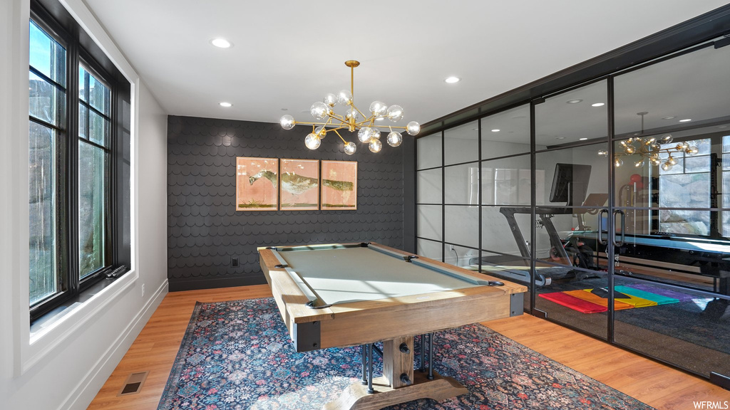 Playroom with a chandelier, light wood-type flooring, a wealth of natural light, and pool table