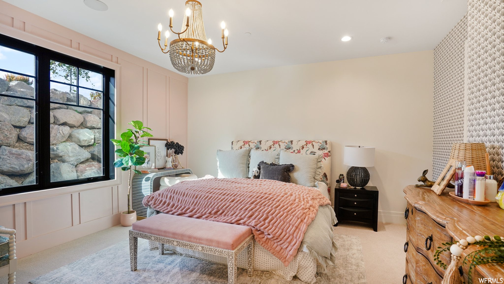Bedroom with light colored carpet and a notable chandelier