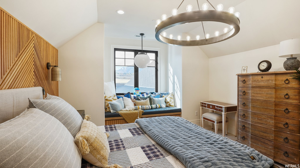 Bedroom with lofted ceiling and a notable chandelier