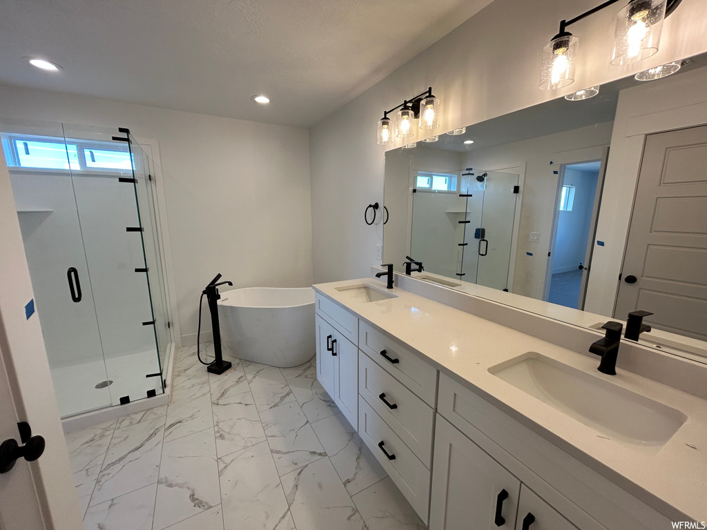 Bathroom featuring shower with separate bathtub, large vanity, tile flooring, and double sink