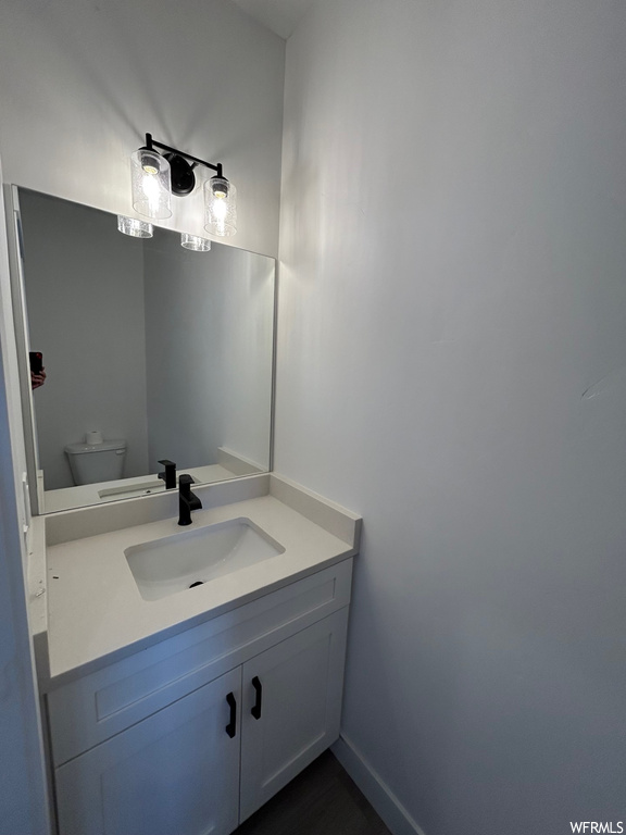 Bathroom featuring large vanity and toilet