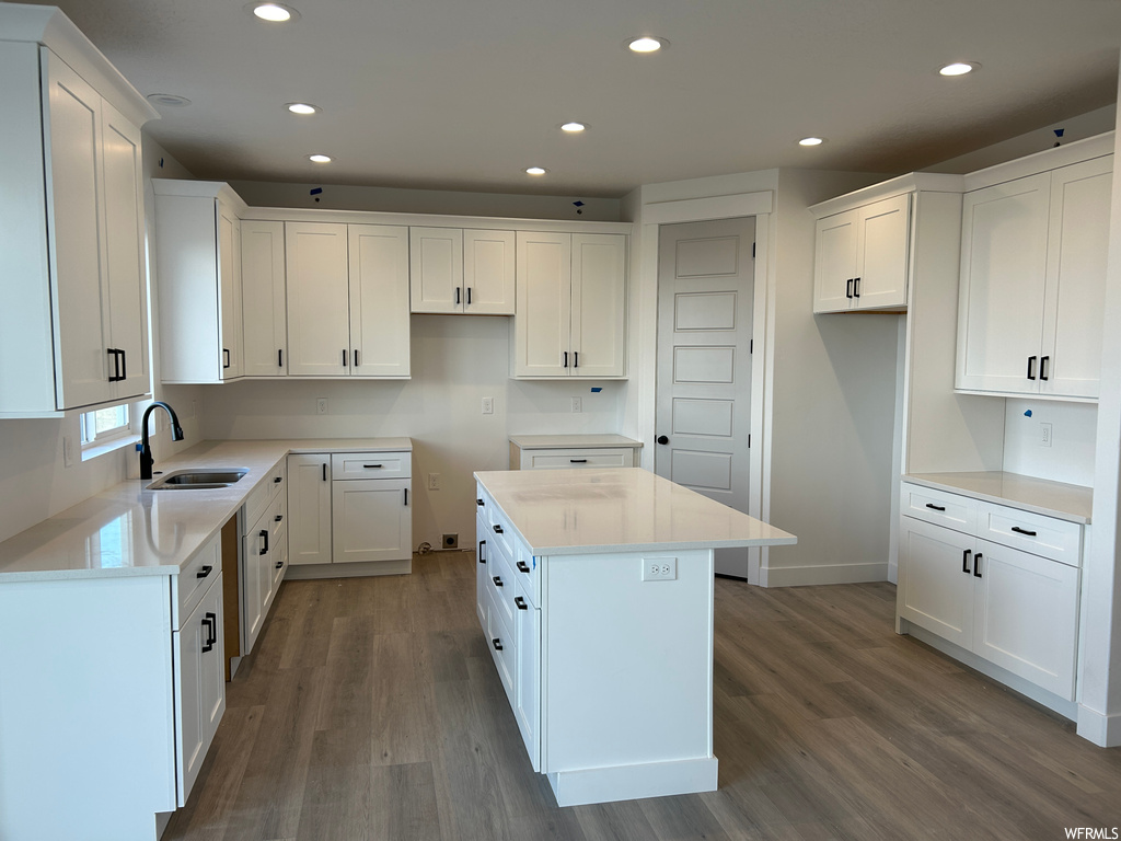 Kitchen featuring sink, a center island, white cabinetry, and light hardwood / wood-style flooring