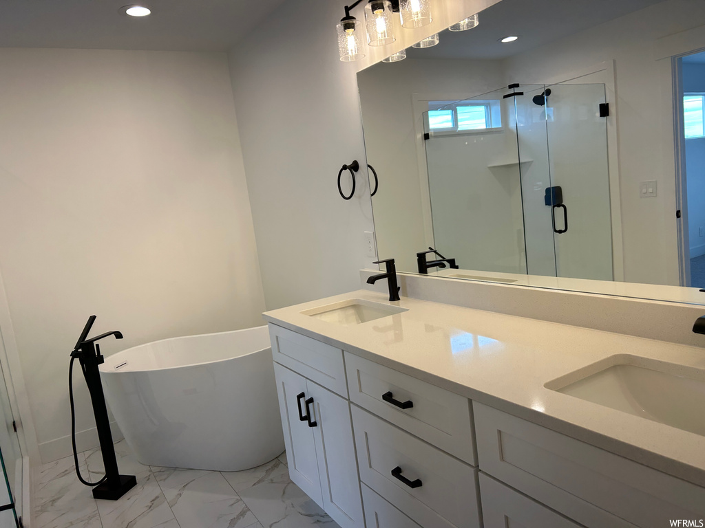Bathroom featuring tile flooring, dual bowl vanity, and shower with separate bathtub