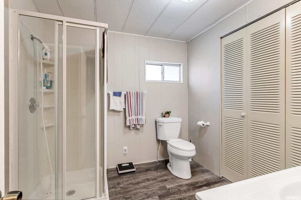 Bathroom featuring sink, walk in shower, wood-type flooring, and toilet