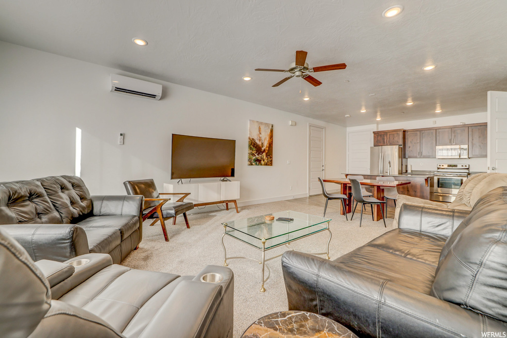 Living room featuring ceiling fan, a wall mounted air conditioner, and light carpet