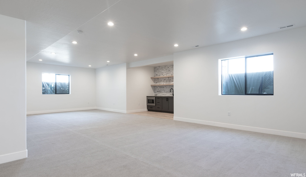 Unfurnished living room with plenty of natural light and light colored carpet