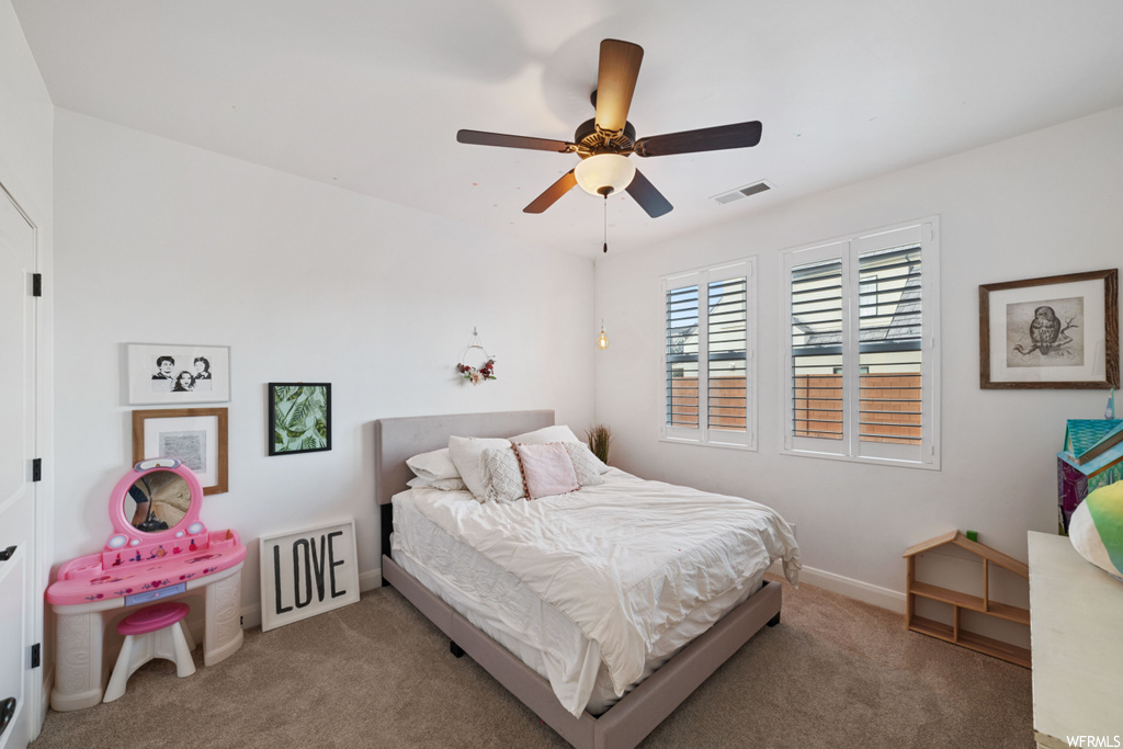 Bedroom featuring ceiling fan and dark colored carpet