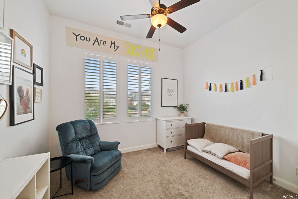 Living area featuring ceiling fan and light carpet