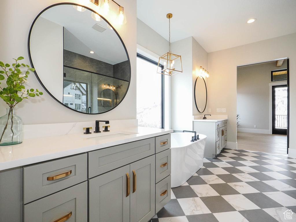 Bathroom featuring a chandelier, independent shower and bath, oversized vanity, and tile flooring