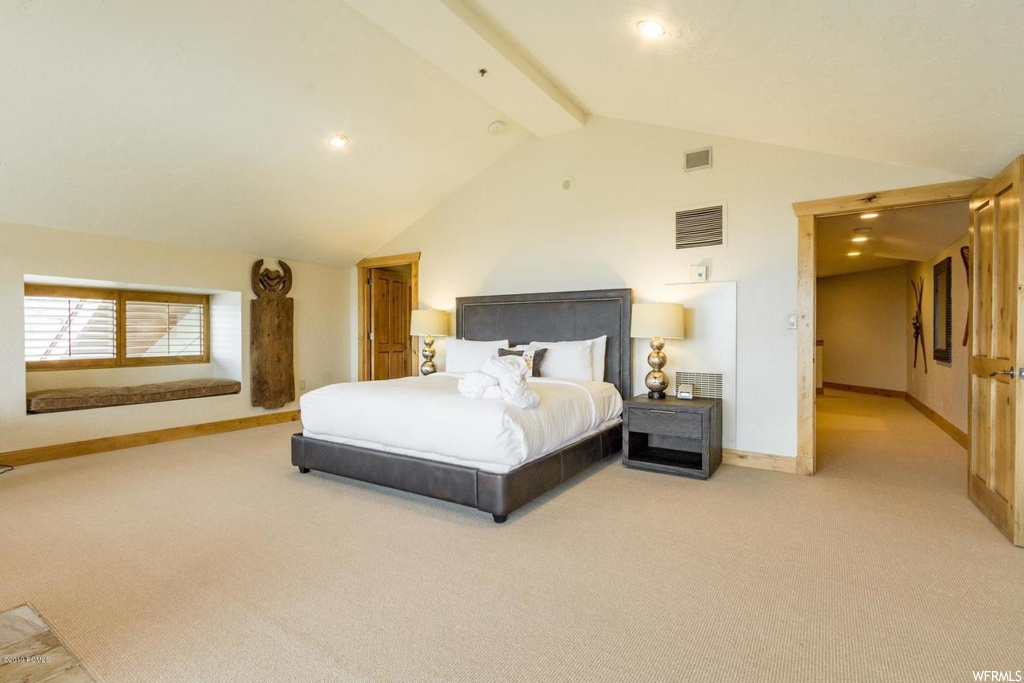 Carpeted bedroom featuring high vaulted ceiling and beam ceiling
