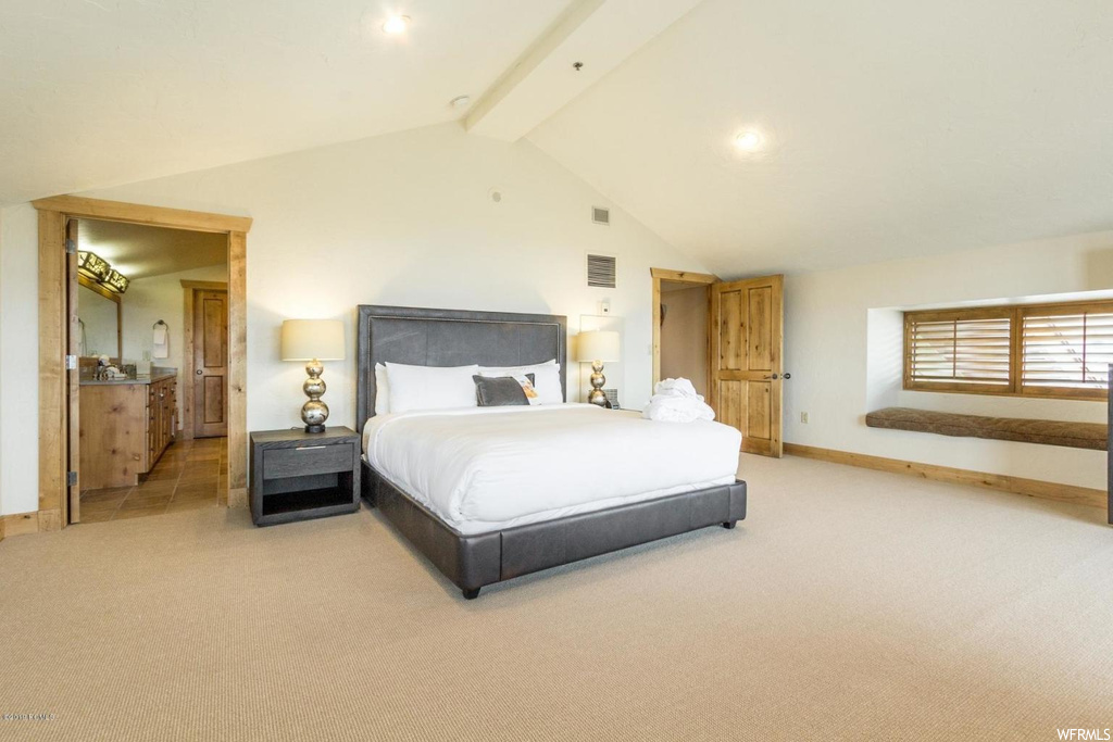 Carpeted bedroom with high vaulted ceiling and beamed ceiling