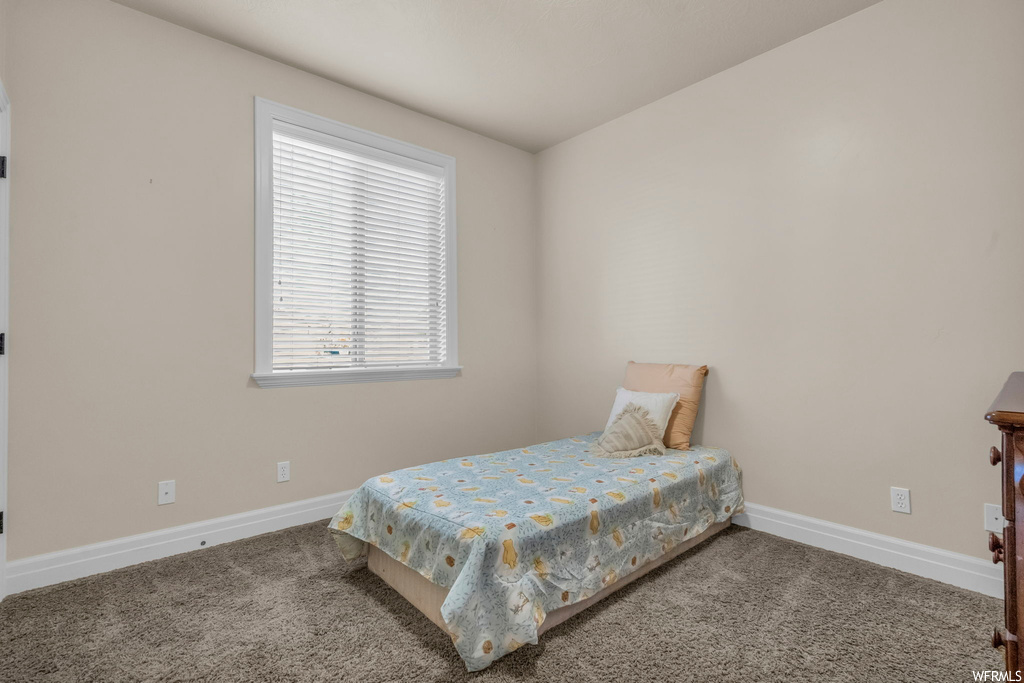 Bedroom with multiple windows and dark carpet