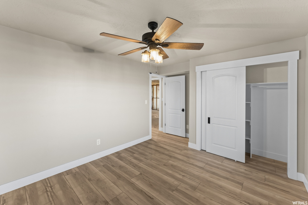 Unfurnished bedroom featuring ceiling fan, light hardwood / wood-style flooring, and a closet