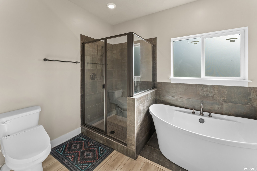 Bathroom featuring separate shower and tub and toilet