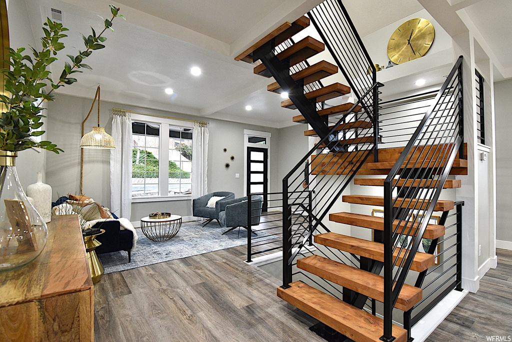 Staircase featuring beam ceiling and dark hardwood / wood-style floors