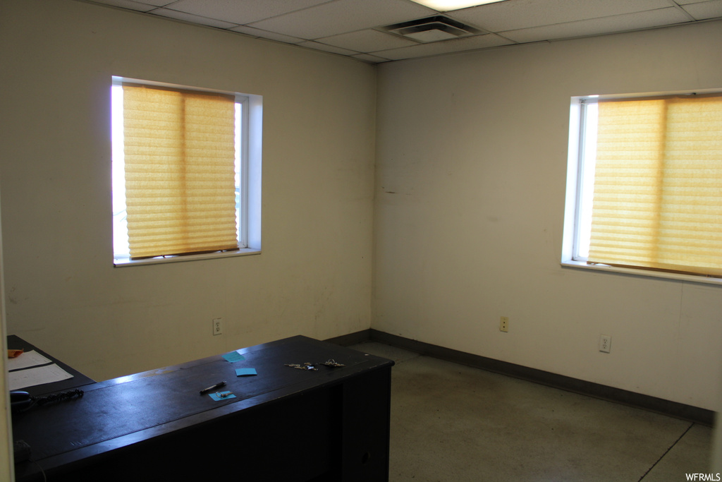 Unfurnished office with a paneled ceiling and plenty of natural light