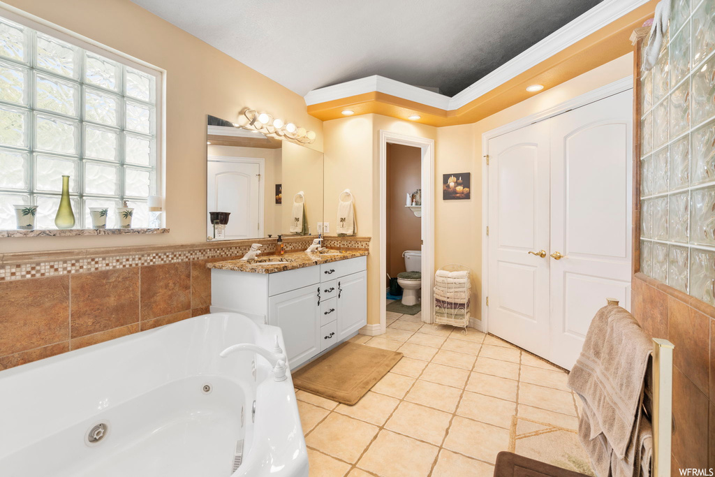 Bathroom featuring tile floors, a washtub, toilet, and oversized vanity