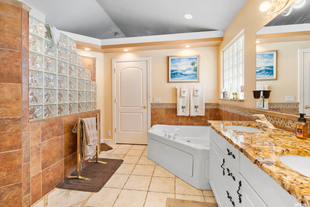 Bathroom with tile flooring, a bathtub, crown molding, double sink, and oversized vanity