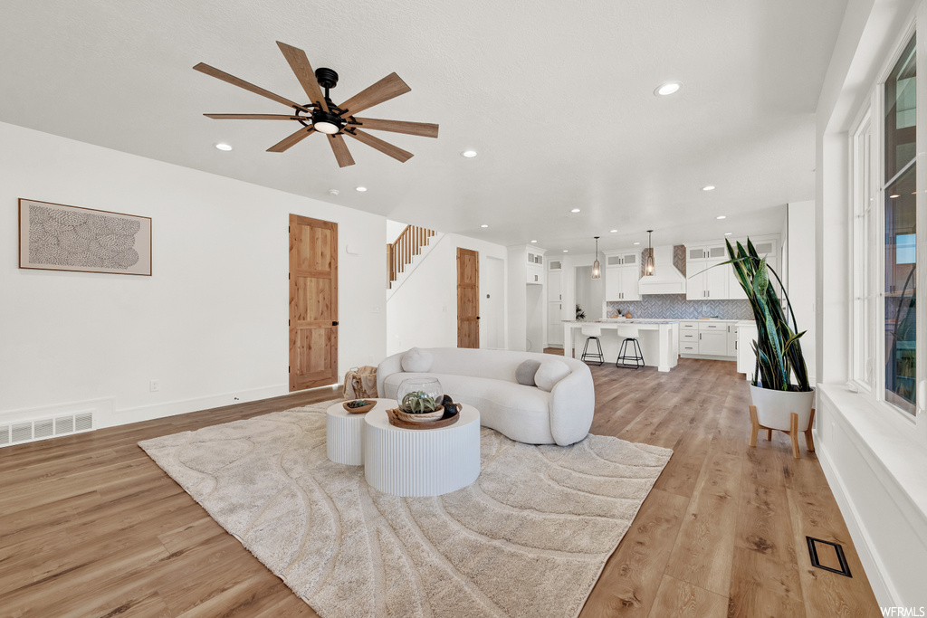 Living room featuring light hardwood / wood-style floors and ceiling fan