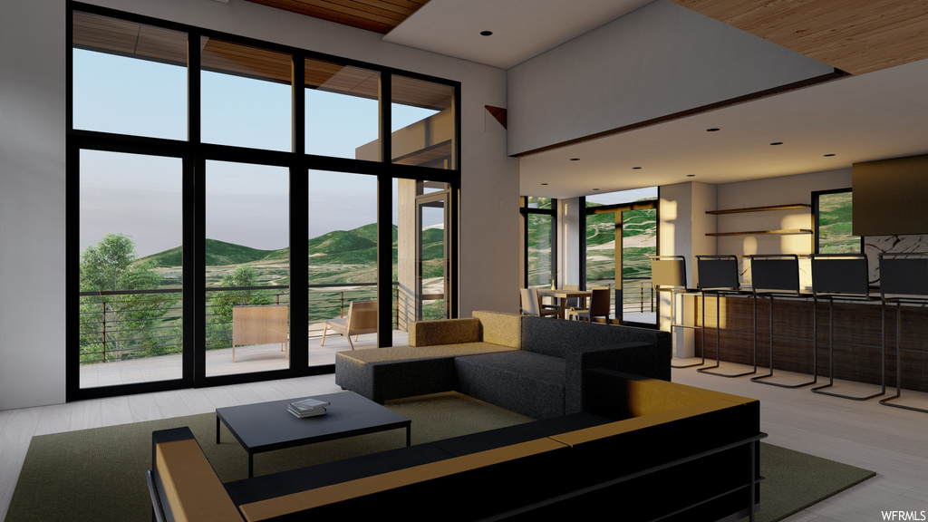 Living room with light hardwood / wood-style floors, floor to ceiling windows, a mountain view, and wooden ceiling
