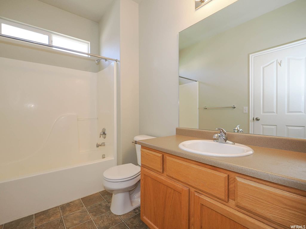 Full bathroom featuring tile flooring,  shower combination, large vanity, and toilet