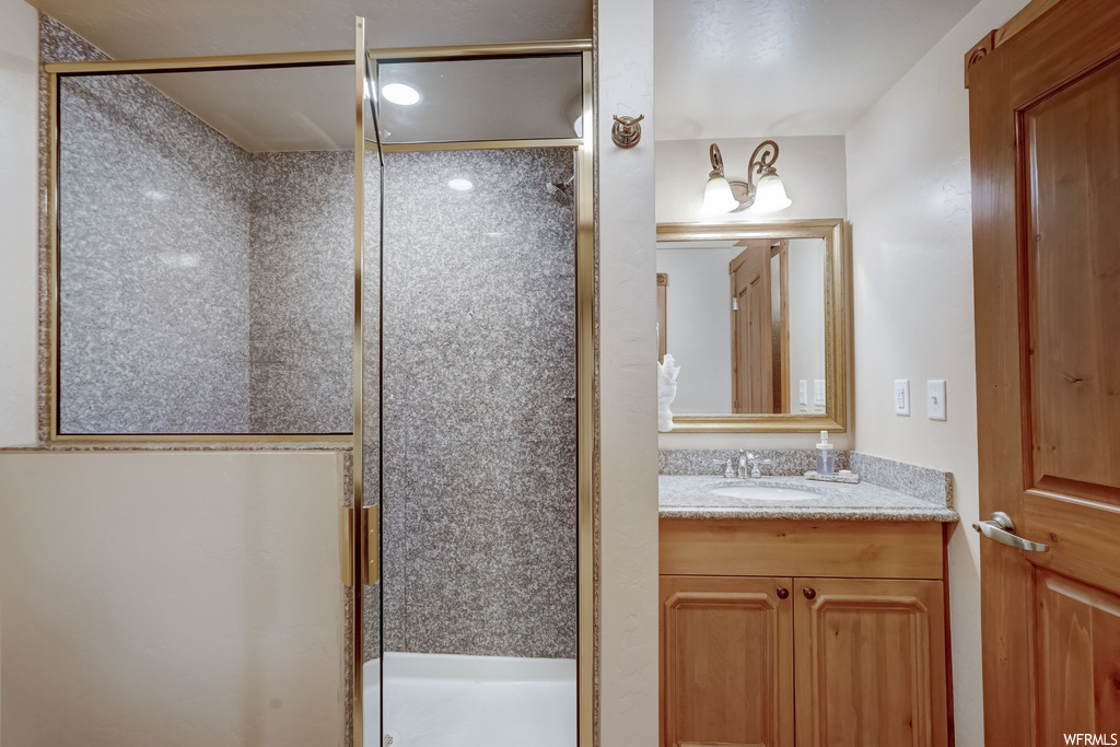 Bathroom featuring large vanity and a shower with shower door