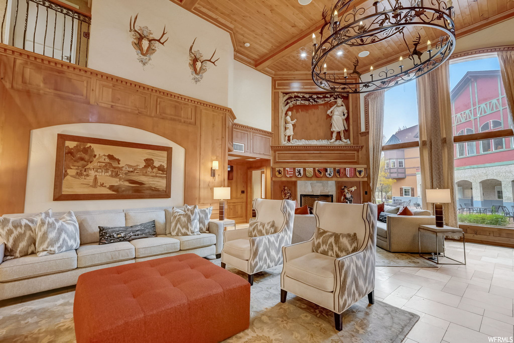 Living room with high vaulted ceiling, light tile floors, a chandelier, wood ceiling, and a fireplace