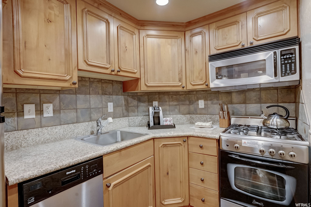 Kitchen featuring sink, tasteful backsplash, and stainless steel appliances