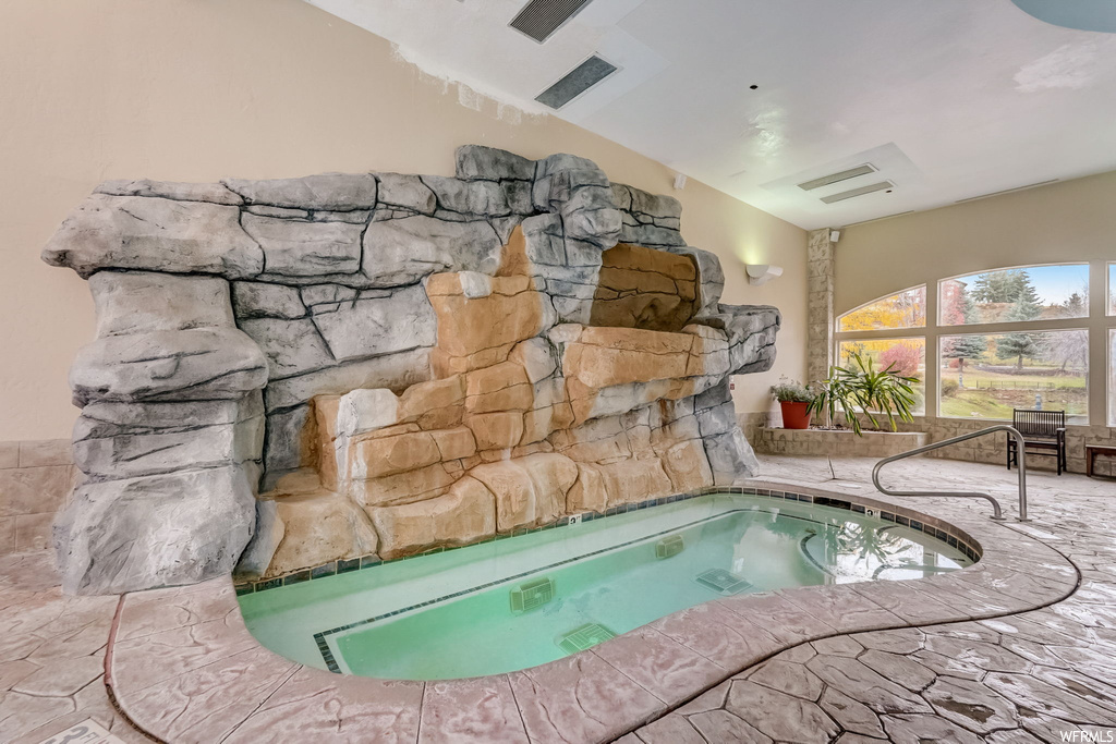 View of pool with an indoor in ground hot tub