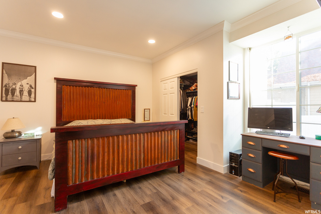 Bedroom with dark wood-type flooring, a closet, and crown molding