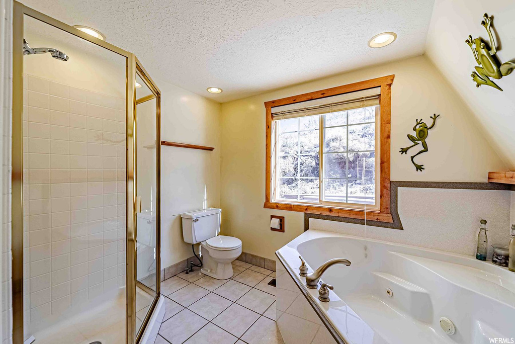 Bathroom with tile flooring, a textured ceiling, independent shower and bath, and toilet