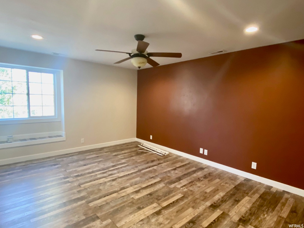 Unfurnished room featuring ceiling fan and wood-type flooring