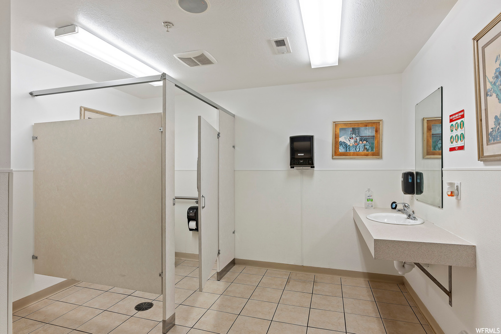 Bathroom featuring tile floors, walk in shower, and oversized vanity