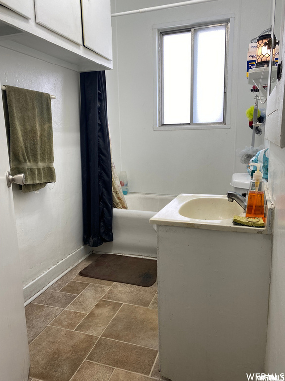 Bathroom featuring tile floors, vanity, and  shower combination
