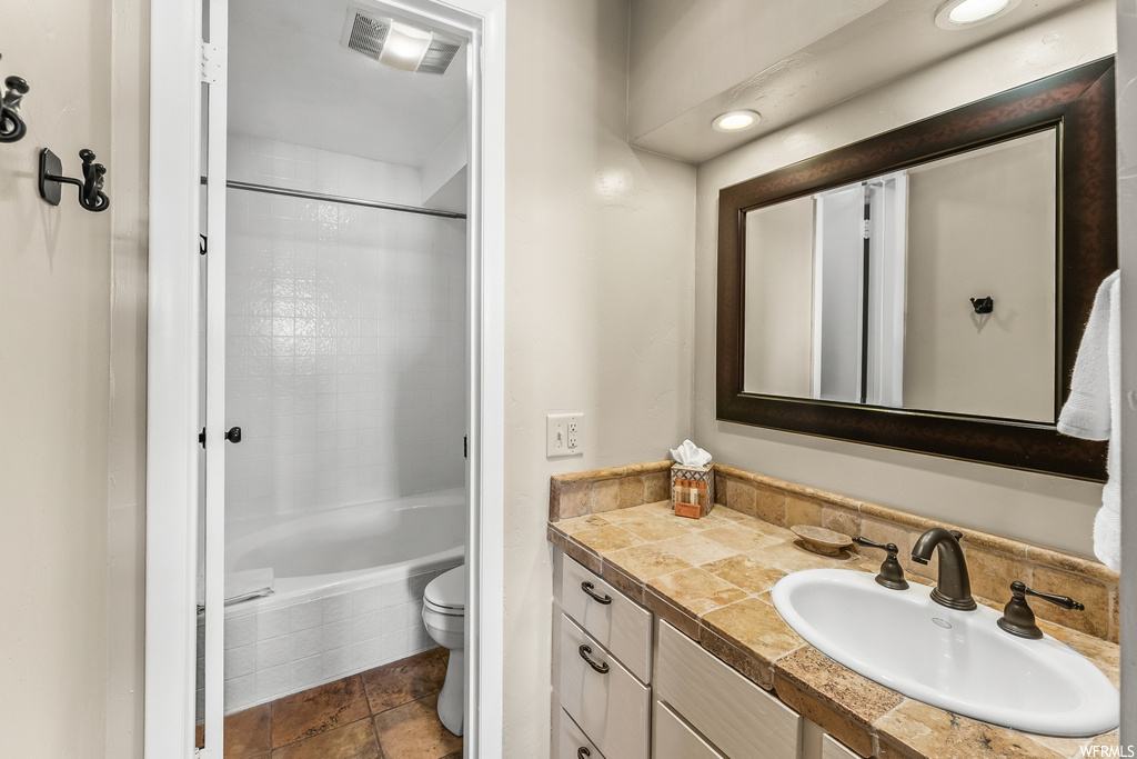 Full bathroom featuring shower / bathing tub combination, large vanity, toilet, and tile floors