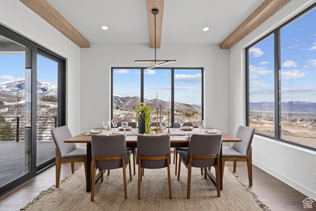 Dining area featuring a mountain view, light hardwood / wood-style floors, and beamed ceiling