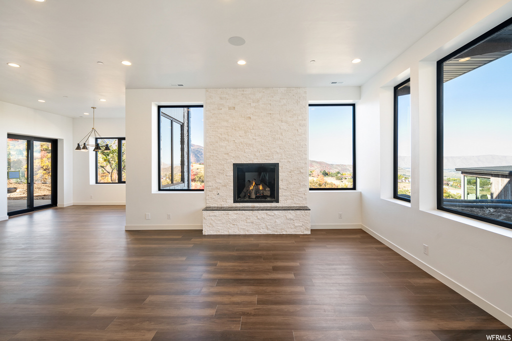 Unfurnished living room with dark hardwood / wood-style flooring and a fireplace