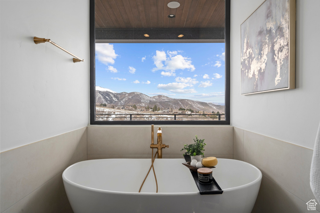 Bathroom featuring a mountain view, wood ceiling, and a bath