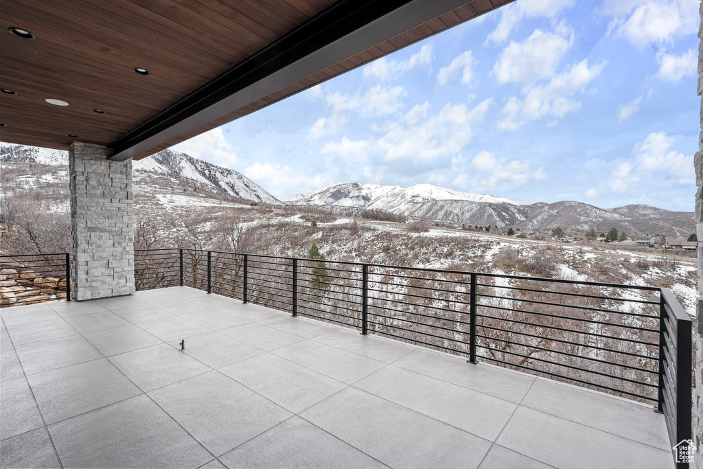 Snow covered patio with a mountain view