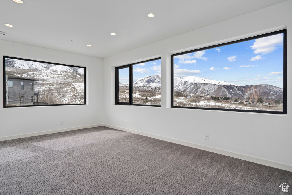 Spare room with a mountain view and carpet floors