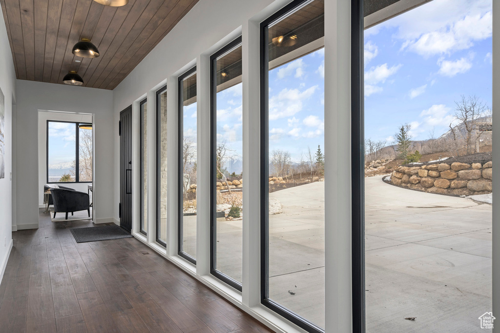 Doorway to outside with wood ceiling and dark hardwood / wood-style floors