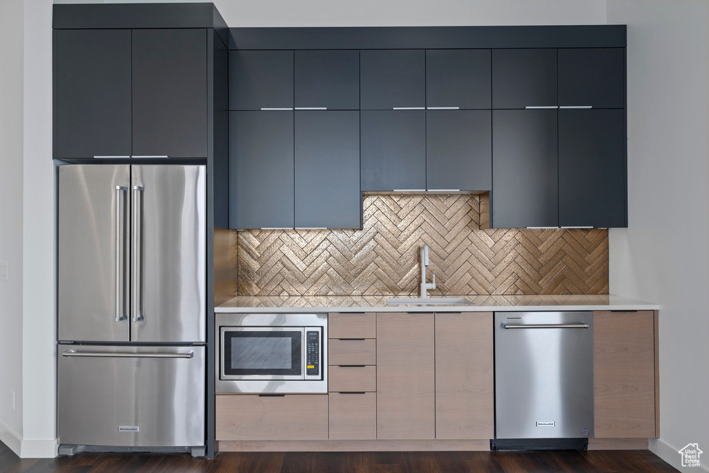 Kitchen with tasteful backsplash, stainless steel appliances, dark hardwood / wood-style floors, sink, and gray cabinets