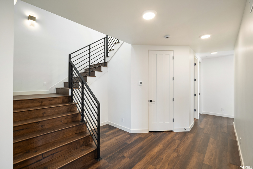 Stairs featuring dark wood-type flooring