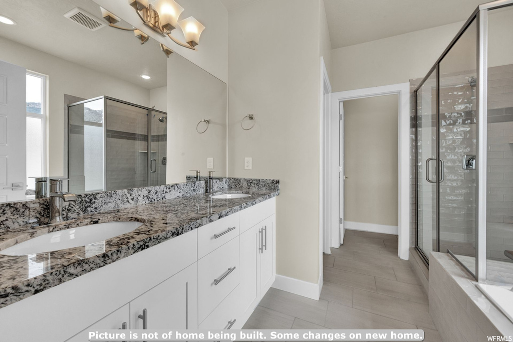 Bathroom featuring an inviting chandelier, walk in shower, tile flooring, and dual vanity