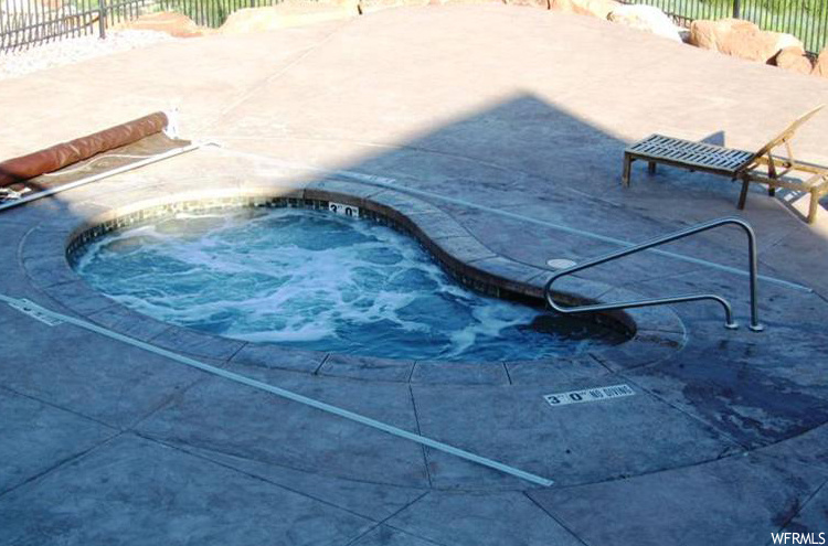 View of pool with a hot tub