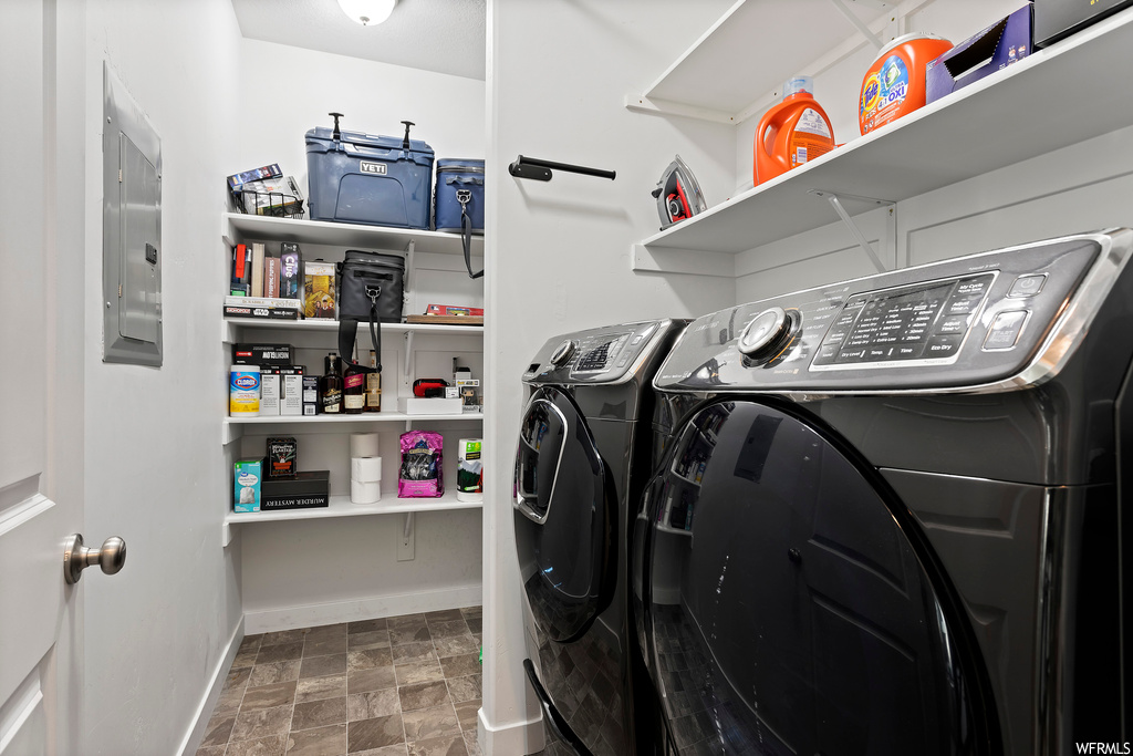 Laundry area with dark tile floors and separate washer and dryer