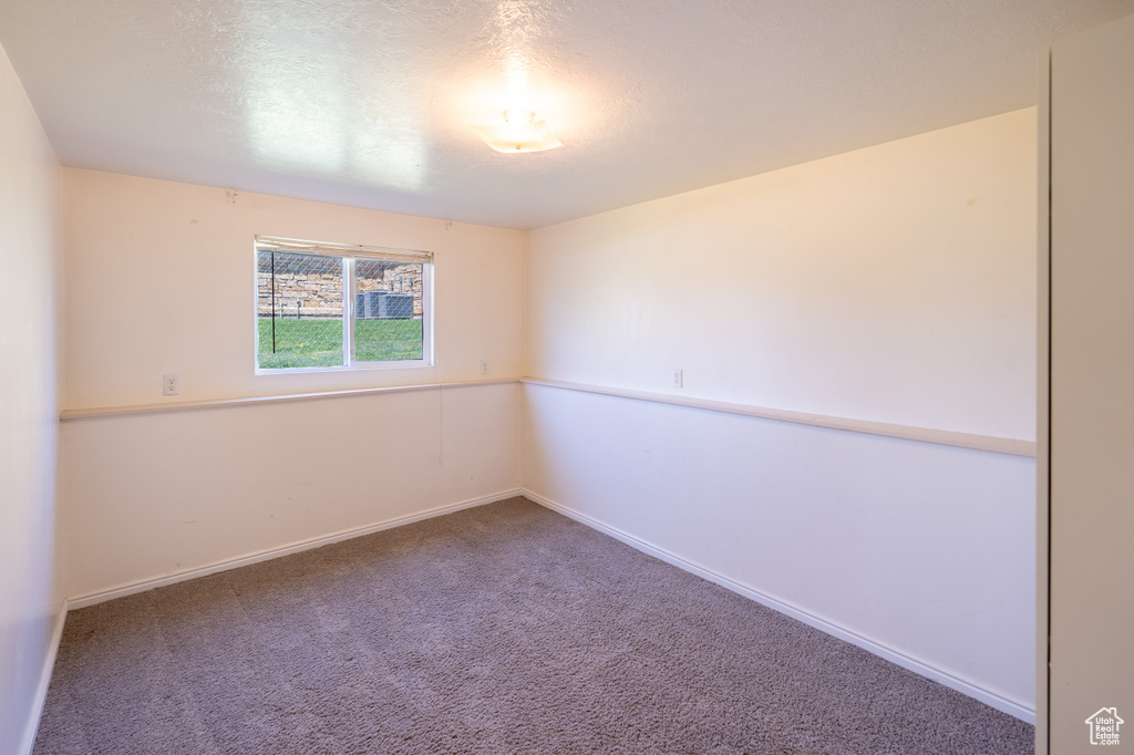 Carpeted empty room featuring baseboards